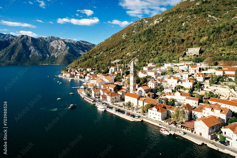 Motor boats are moored off the coast of Perast opposite the bell tower of the Church of St. Nicholas. Montenegro. Drone
