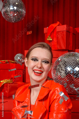 Obraz na płótnie Beautiful girl in shiny red patent leather jacket at a red festive location. Photo shoot in the studio, celebration w salonie
