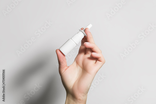 hand holding a white bottle with nasal spray photo