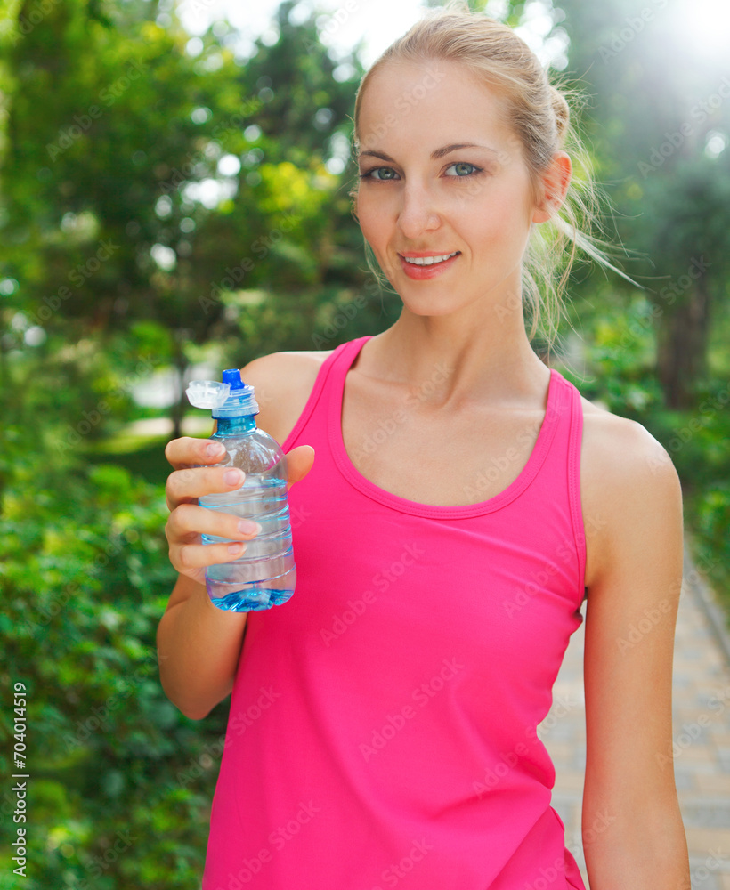 Woman drinking water after fitness exercise Woman drinking water after fitness exercise