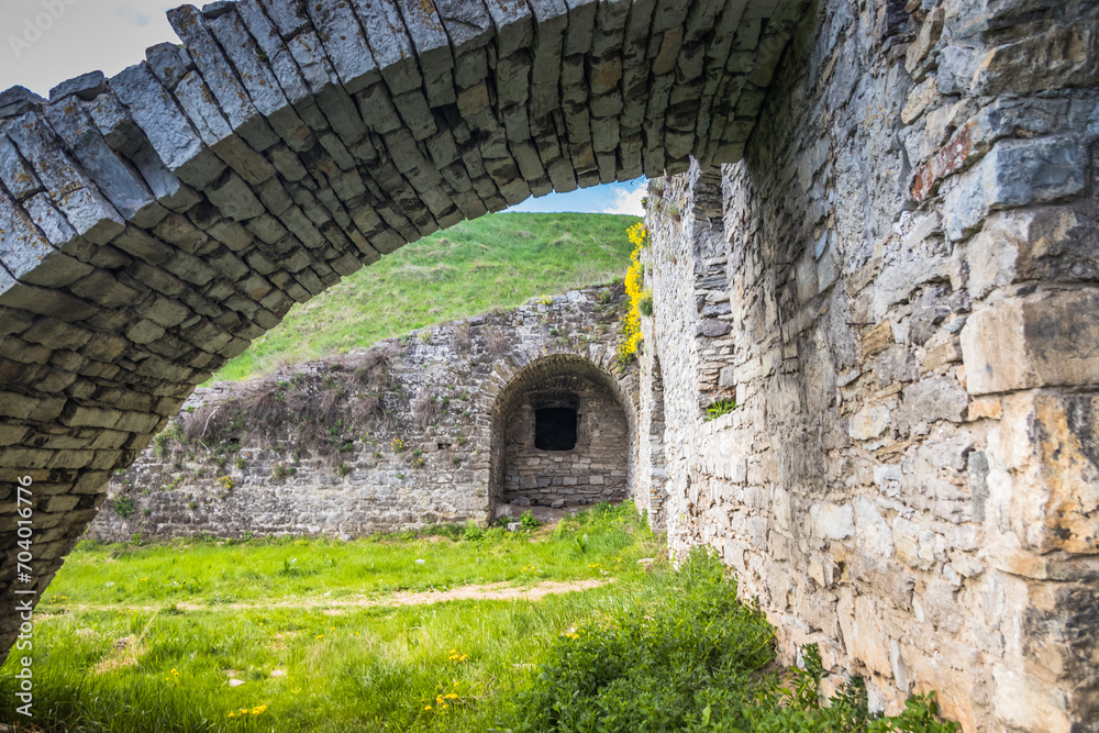 Old Kamianets-Podilskyi Castle under the blue sky. Part of the powerful bastions of the castle. The fortress located among the picturesque nature in the historic city of Kamianets-Podilskyi, Ukraine