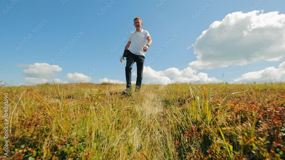Man go in Vast Meadow, Tourist man go in a field. A man's walk through the field Man go in Vast Meadow, Tourist man go in a field. A man's walk through the field
