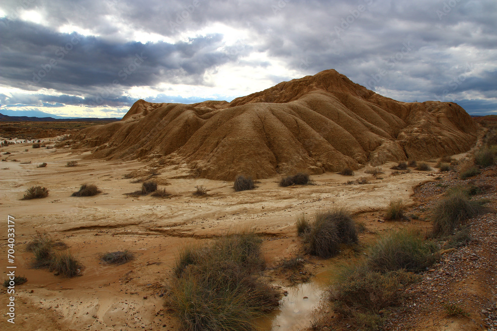 Under a stormy October sky, view of a mini-canyon dug into the clay layers of Bardena Blanca in the Bardenas Reales (Spanish Navarre)