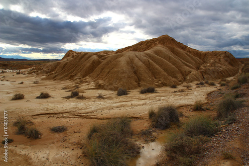 Under a stormy October sky, view of a mini-canyon dug into the clay layers of Bardena Blanca in the Bardenas Reales (Spanish Navarre) photo