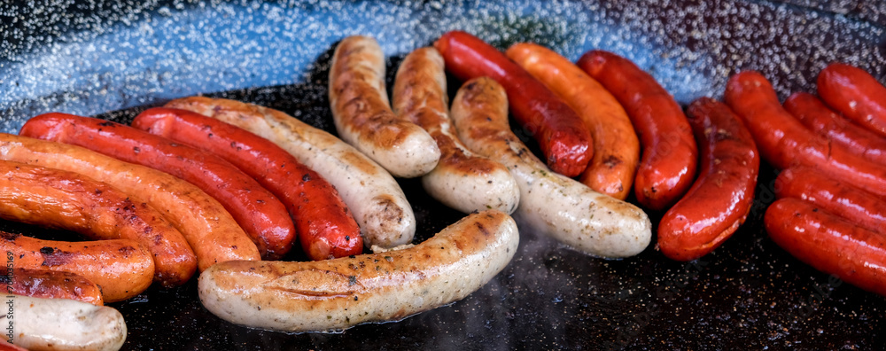 Fototapeta premium ..Cooking different types of sausages on the grill. Delicious sausages close-up. Banner