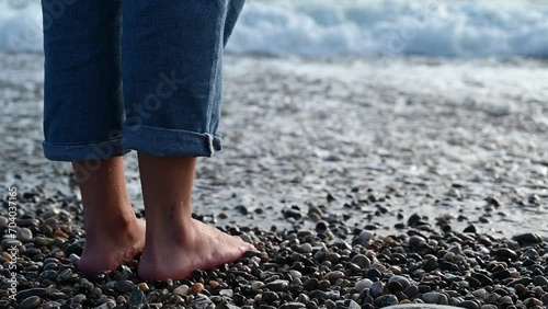 Female feet step on the sea wave
 photo