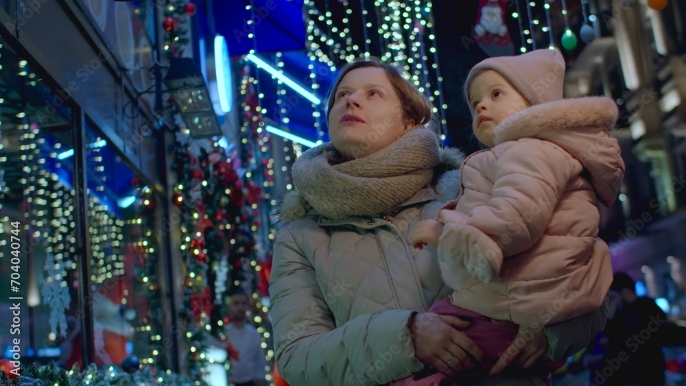 Mother with daughter on street for Christmas eve, Christmas lights and christmas mood leisure activity with child. Happy mother walking with her baby in town. Mother with daughter on street for Christmas eve, Christmas lights and christmas mood leisure activity with child. Happy mother walking with her baby in town.
