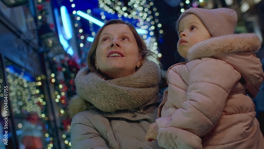 Mother with daughter on street for Christmas eve, Christmas lights and christmas mood leisure activity with child. Happy mother walking with her baby in town. Mother with daughter on street for Christmas eve, Christmas lights and christmas mood leisure activity with child. Happy mother walking with her baby in town.