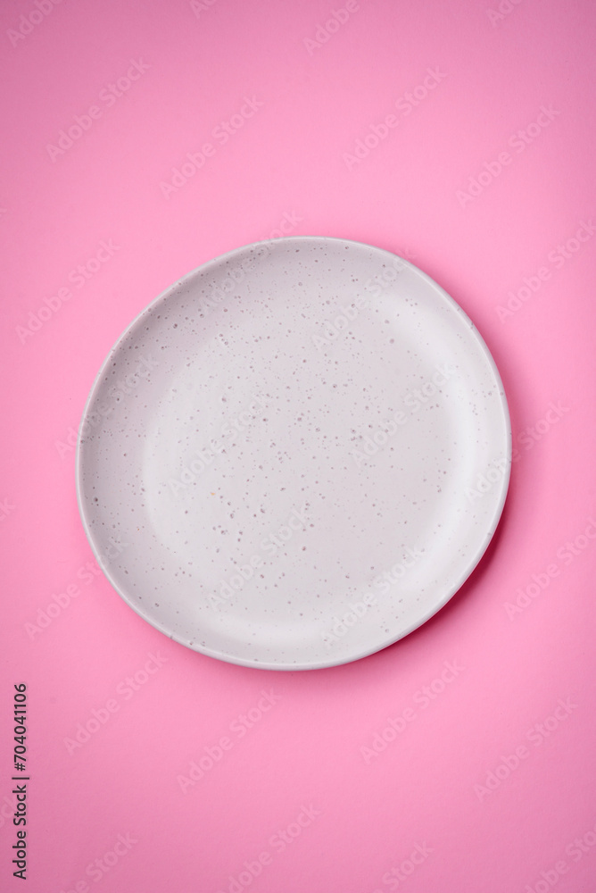 Empty round ceramic plate on a plain background, flatley with copy space Empty round ceramic plate on a plain background, flatley with copy space