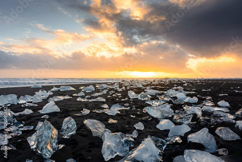 Amazing sunset over the Diamond Beach, volcanic black beach with icebergs from the Jokulsarlon glacier lagoon,  Iceland