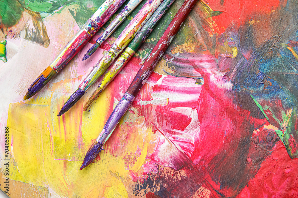 Fototapeta premium Dirty paint brushes on colorful background
