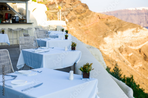 Tables on the caldera cliff of a Santorini hotel with great aegean sea view greece © GreeceYou