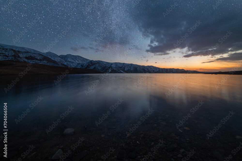 Beautiful night landscape. Small lake and mountains in the starry night.