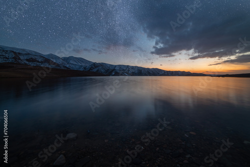 Beautiful night landscape. Small lake and mountains in the starry night. © Inga Av