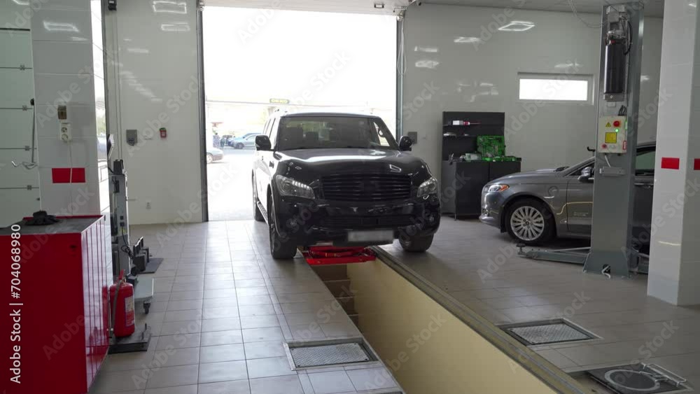 Vehicle enters auto workshop for check-up. Modern garage, car inspection, owner drives, shop tools ready. Professional maintenance, diagnostics in bright, updated service center. SUV approach