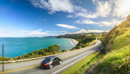 cars driving on coastal road n west coast of coromandel peninsula north island new zealand