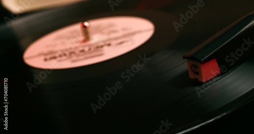 Vinyl record close-up. Vintage old vinil black phonograph spinning. Retro music player on living room home background in evening.
