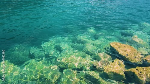 Rocky sea floor visible through crystal clear turqoise water of Aegean sea in Sithonia. photo