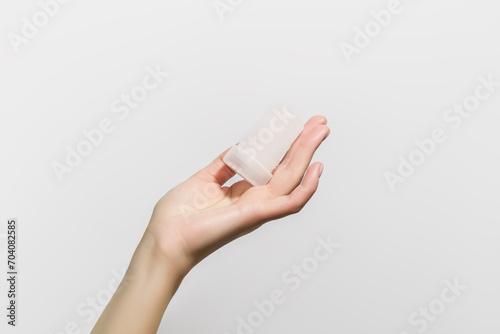 female hand holding mineral potassium alum crystal stick. natural deodorants concept photo