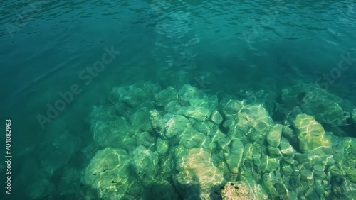 Rocky sea floor visible through crystal clear turqoise water of Aegean sea in Sithonia. photo