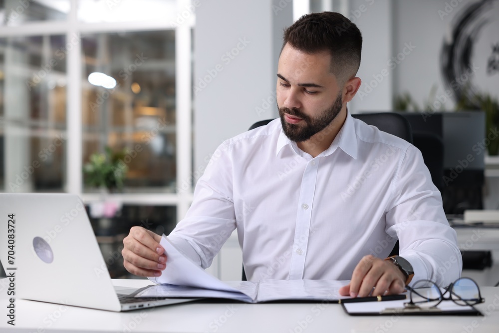 Handsome man working at table in office. Lawyer, businessman, accountant or manager