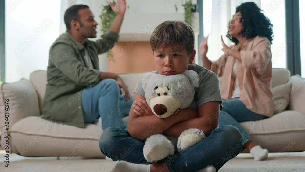 Sad little child boy hug teddy toy while mom dad fighting screaming ...