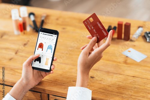 Fototapeta Naklejka Na Ścianę i Meble -  Woman shopping online on internet marketplace browsing for sale items for modern lifestyle and use credit card for online payment from wallet protected by uttermost cyber security software