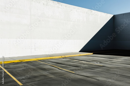 A modern marvel of urban design, this parking lot seamlessly blends into the sky with its sleek composite material, leading to a tunnel that disappears into the ground, surrounded by bold lines and c