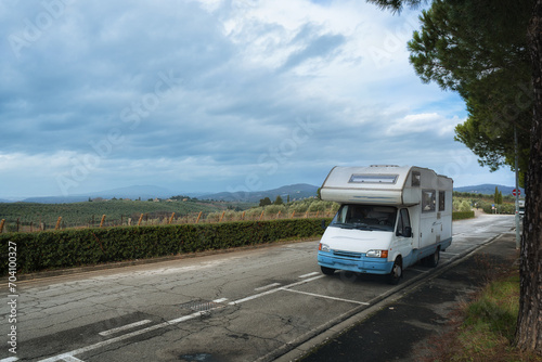 A camper stands on a road in Tuscany. Vineyards and landscapes of winter Italy.