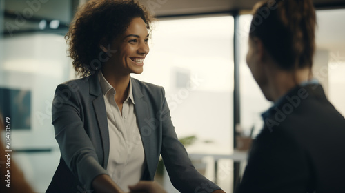 Bella donna sorridente in un moderno ufficio con abito elegante incontra un cliente e le stringe la mano