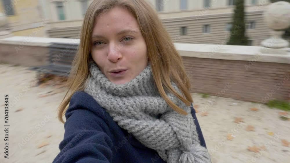 In the midst of autumn's charm, a beautiful young blonde takes a video selfie in a park, capturing the essence of the season In the midst of autumn's charm, a beautiful young blonde takes a video selfie in a park, capturing the essence of the season