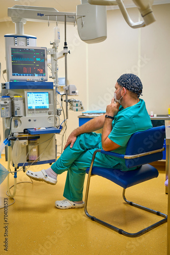 the anesthesiologist monitors the screens during the operation