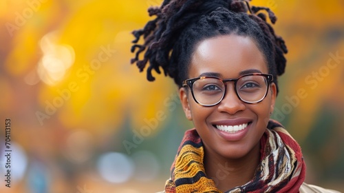 Portrait of black woman with glasses and smiling isolated on orange autumn bokeh background with copy sauce. photo