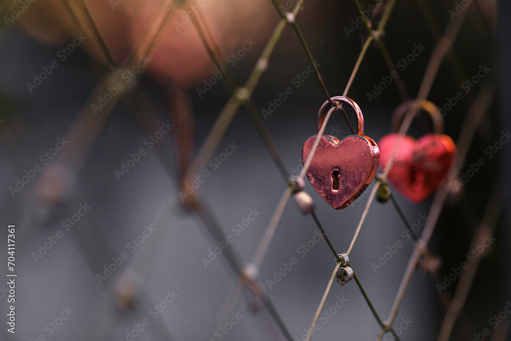A red padlock hanging on a bridge fence as a sign of love and romance.