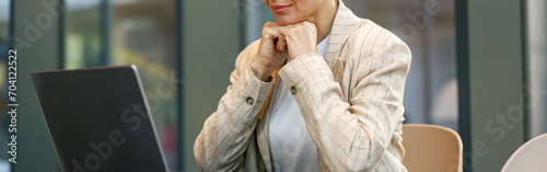 Stylish business woman sitting in modern coworking and working on laptop. High quality photo