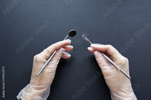 hand holding a dental tool isolated on black background. dental