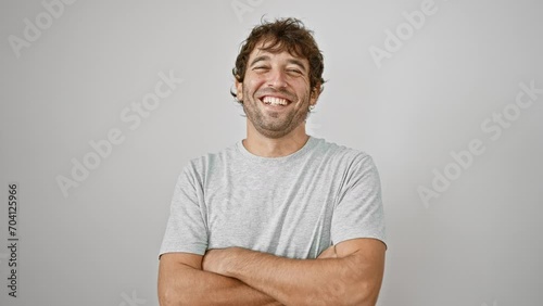Confident young man with crossed arms, smiling happily at the camera over isolated white background photo