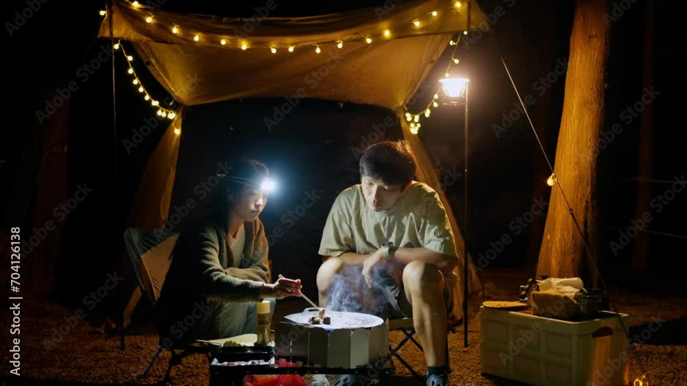 Couple go camping and enjoy cooking together in the camp site Couple go camping and enjoy cooking together in the camp site