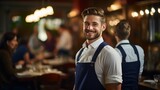 Confident waiter in apron standing in restaurant