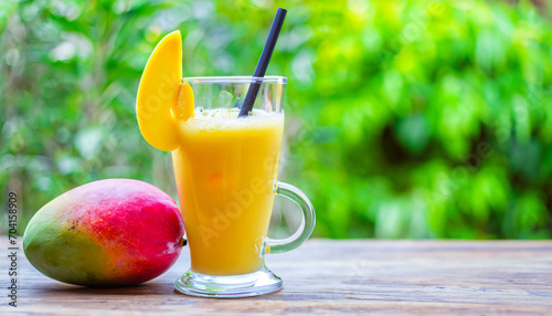 Fresh tropical fruit smoothie mango juice and fresh mango on a outdoor tropical background. Copy space.