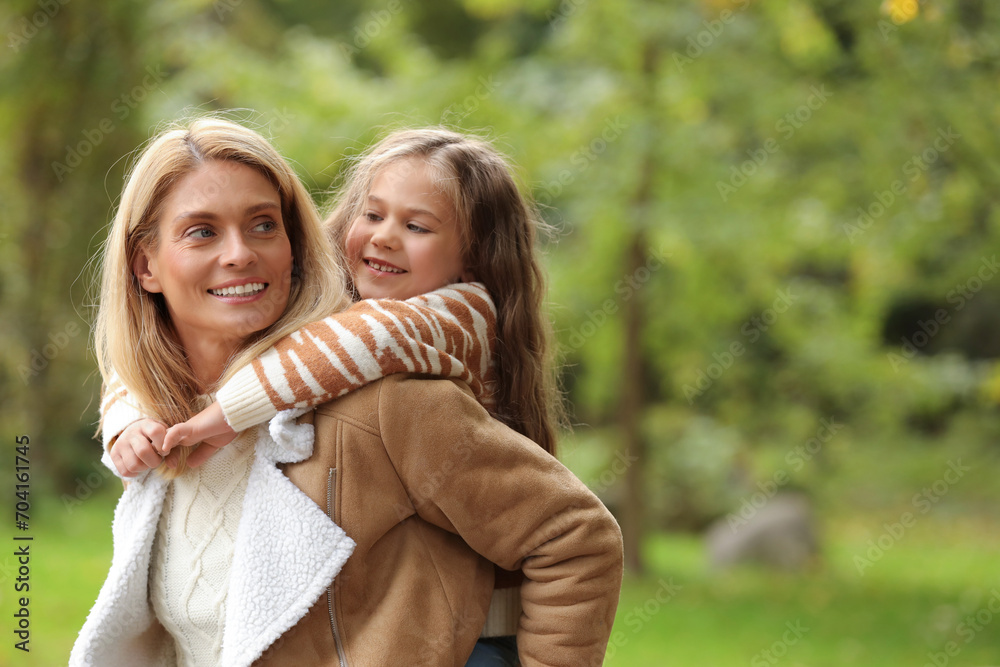 Happy mother walking with her daughter in autumn park, space for text Happy mother walking with her daughter in autumn park, space for text