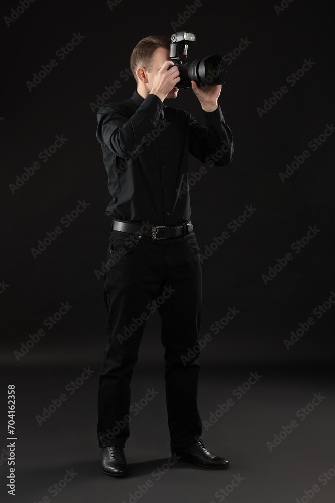 Professional photographer taking picture on black background Professional photographer taking picture on black background