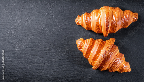 Fresh croissant on a black slate background. Top view Copy space