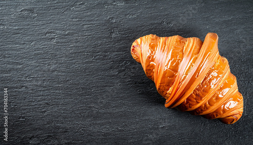 Fresh croissant on a black slate background. Top view Copy space