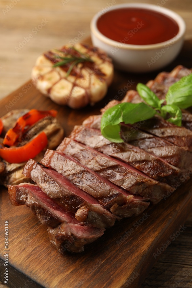 Delicious grilled beef steak with spices and tomato sauce on table, closeup
