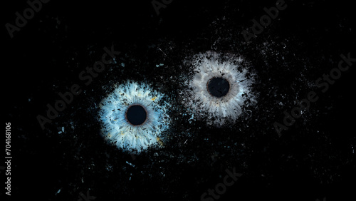 Galaxy explosion effect of human eyes colliding on black background. Close-up of blue and grey colored iris. Structural Anatomy. Iris Detail. High Resolution.