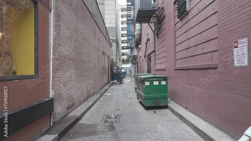 A forward POV dolly shot walking down an alley in a large city.  	