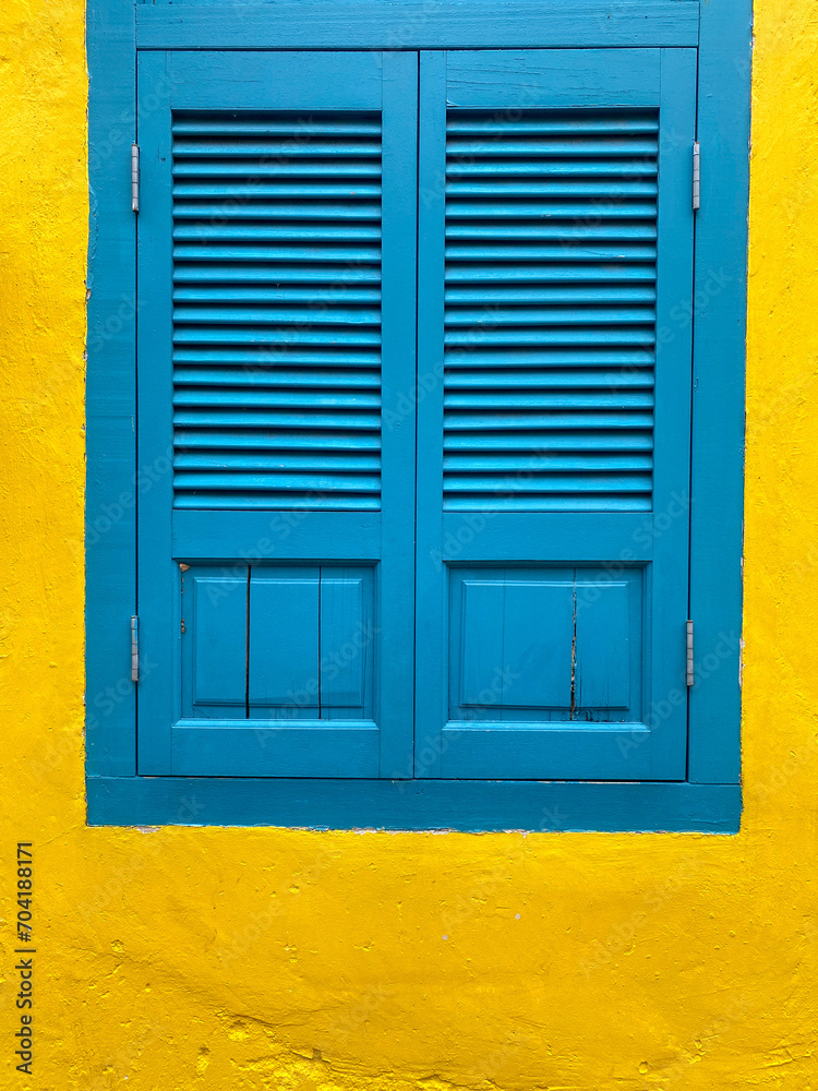 Blue window isolated on the background of a yellow ragged wall. Blue window isolated on the background of a yellow ragged wall.