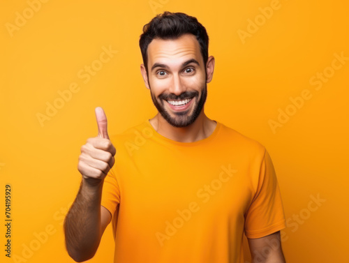 Portrait of man giving thumbs up isolated on orange background