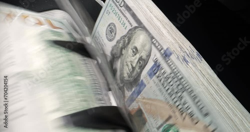 Device for counting, one hundred dollar bills rustle in stack. Special equipment for counting money. American dollar is being counted, smooth camera sliding. Machine counts money for financial use.
